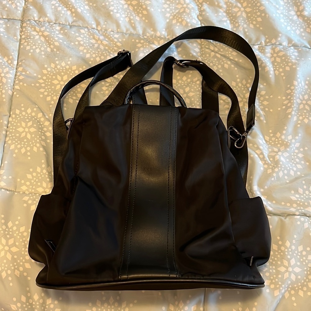 Black backpack, with strap and handle.
